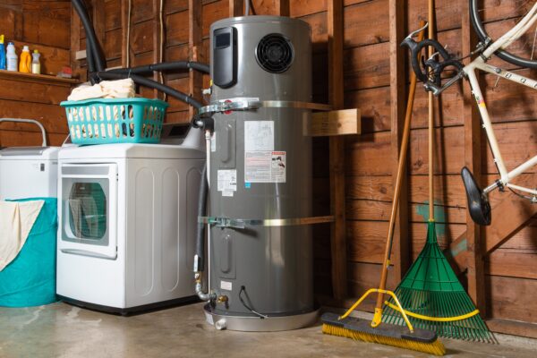 Interior viewe of residential garage housing washer/dryer, heat pump water heater bicycle and gardening tools - photo