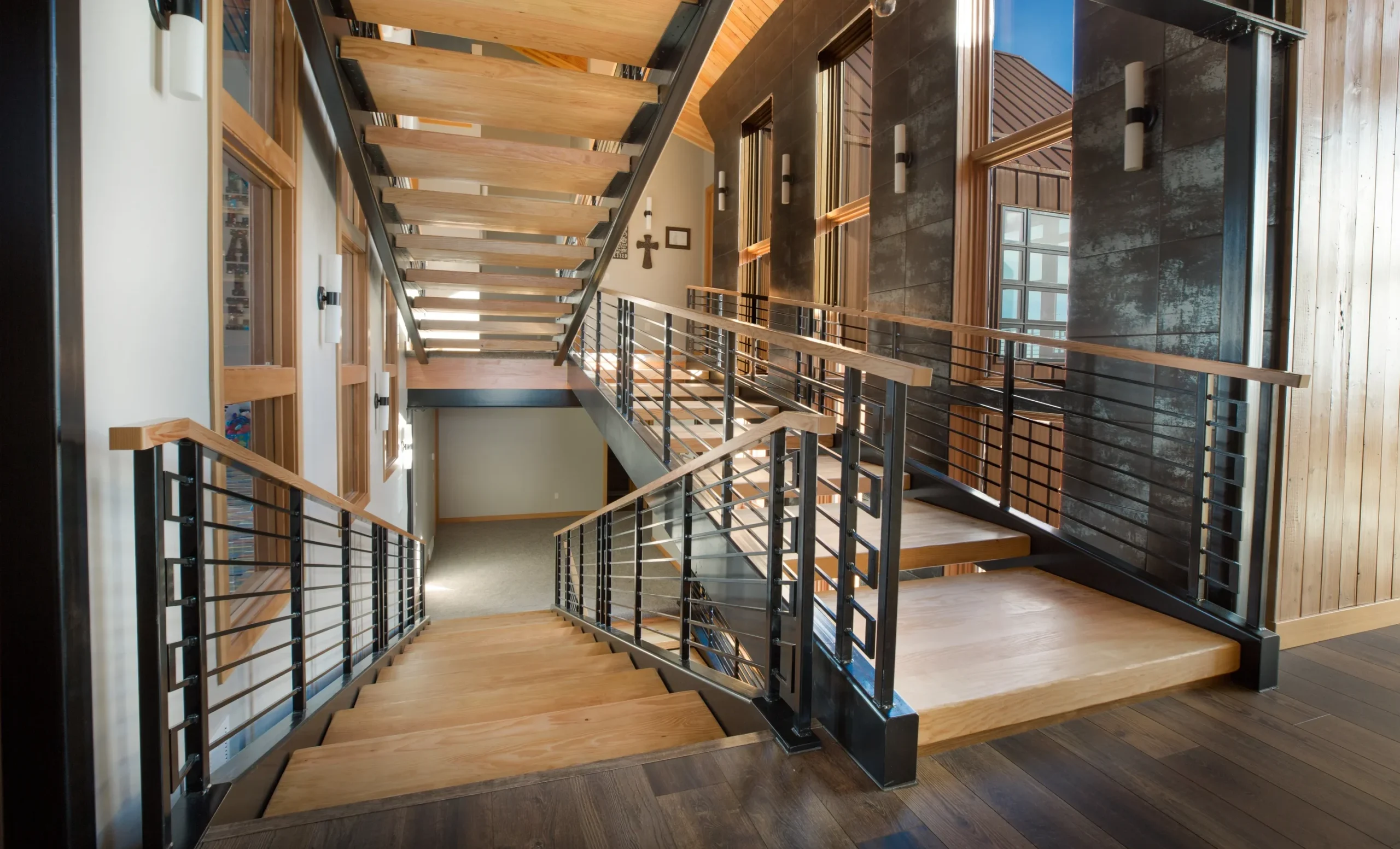 interior view of SIP home features modern, sculptural stair of wood treads and meal banisters; windows on both sides - photo