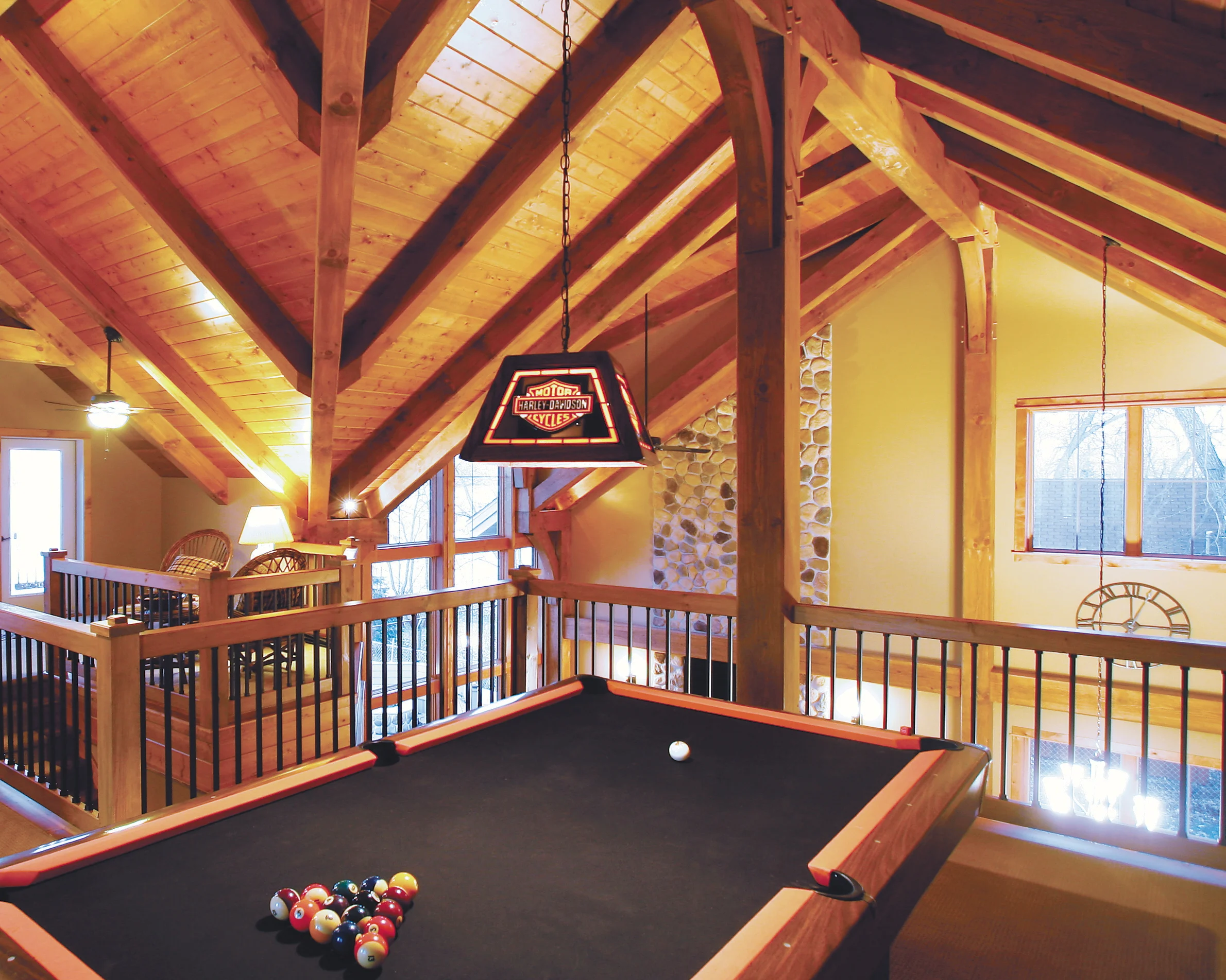 interior of timber frame home with SIP construction covered by wood ceilings; pool table and eclectic decor - photo