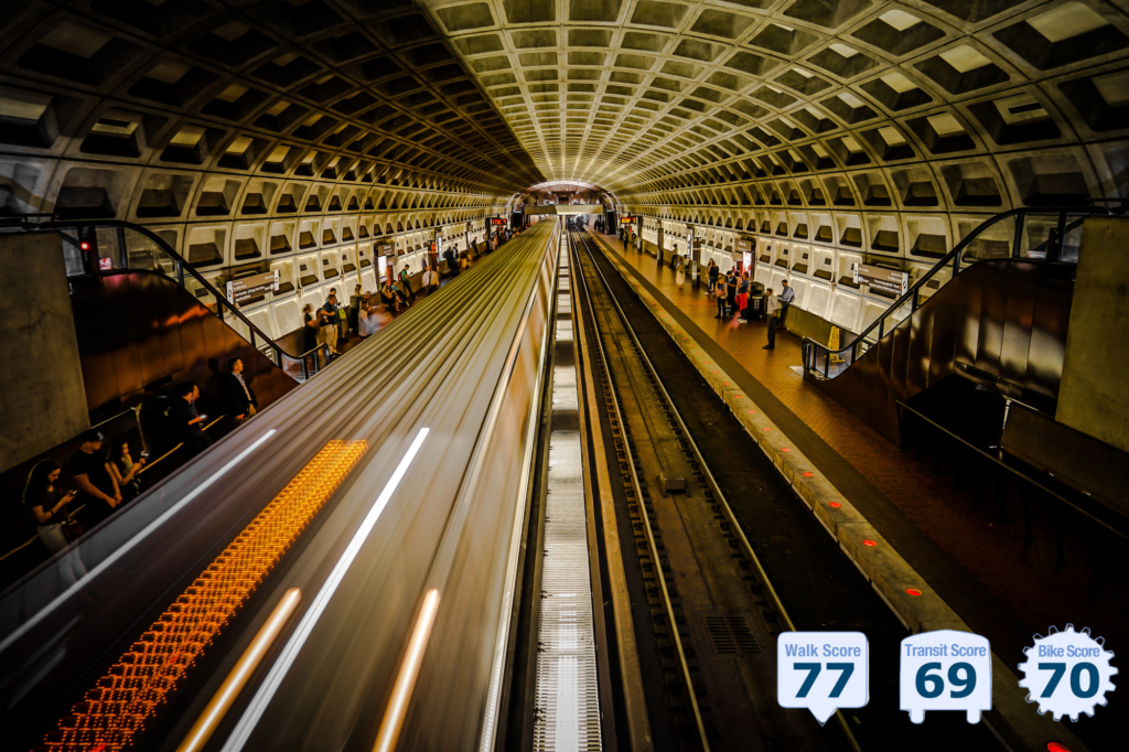 point of view above the tracks of the Washing DC subway; travelers on platforms; blurred train speeding through; and curving coffered ceiling - photo