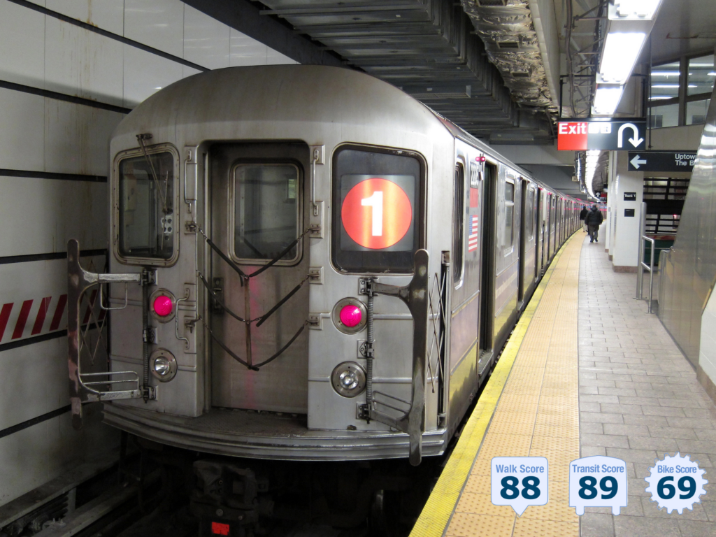 biew from platform of modern clean-looking NYC subway; a few travelers on the platform; 1 train is parked in the station; embedded text reads Walk Score 88 - photo